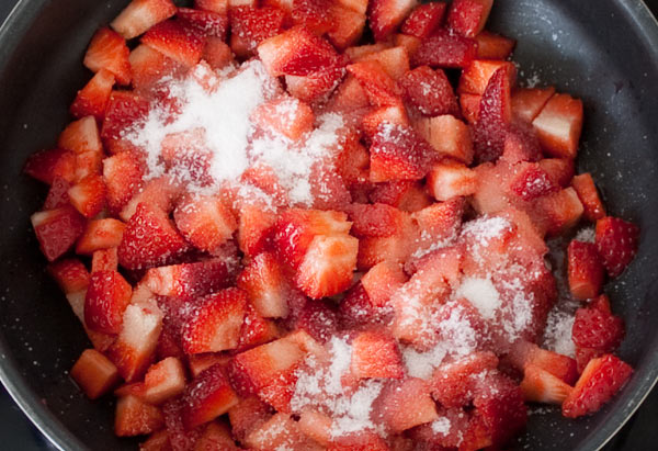 Añadir el azúcar a las fresas y hacer la salsa para la tarta de queso rápida