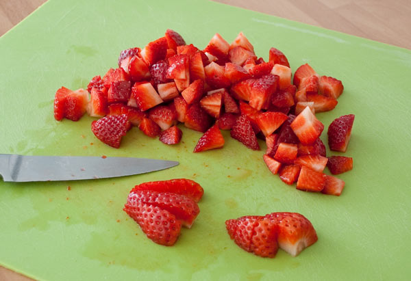 Cortar las fresas en trozos para hacer la tarta de queso rapida en vasito