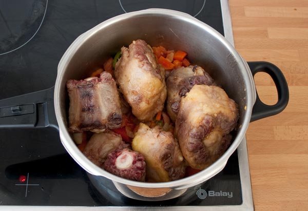 Agregar los trozos de rabo de toro a la olla exprés