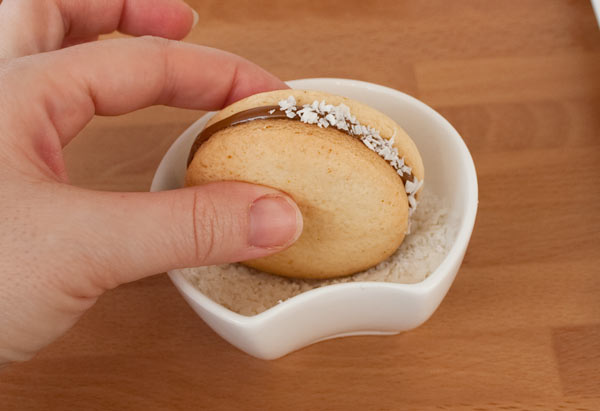 Rebozar en coco el borde de los alfajores de maicena