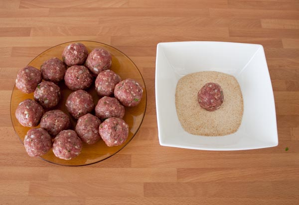 Rebozar en pan rallado las albóndigas al horno