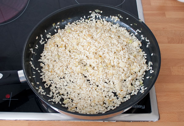 Sofreír el arroz del risotto de gorgonzola, peras y nueces