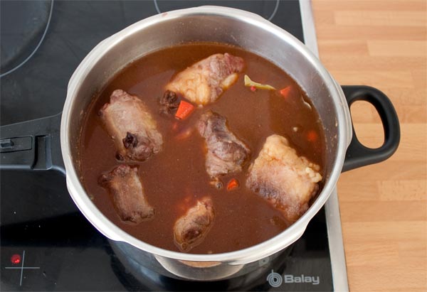 Agregar el caldo y el vino tinto al rabo de toro