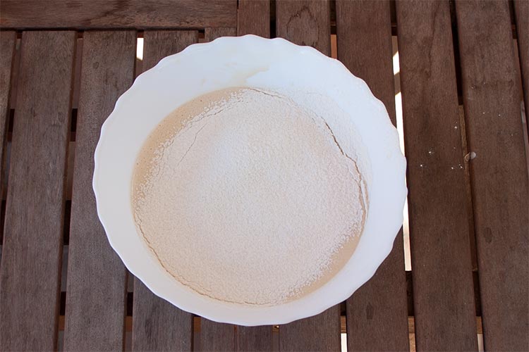 Agregar la harina tamizada a la masa del bizcocho de yogur y melocotón