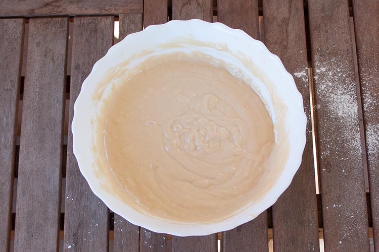Добавьте муку и дрожжи и полностью вмешайте их в тесто для йогуртового торта.