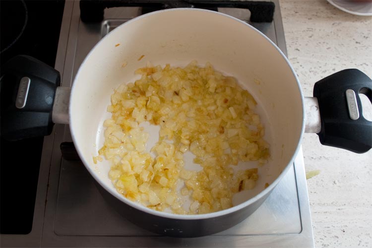 Pochar la cebolla en la mantequilla para hacer croquetas con queso azul