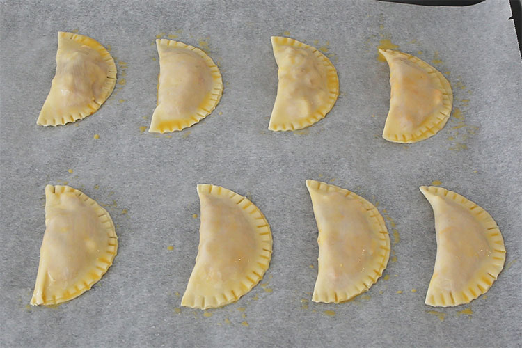 Pintar con huevo las empanadillas de sobrasada, queso y cebolla caramelizada