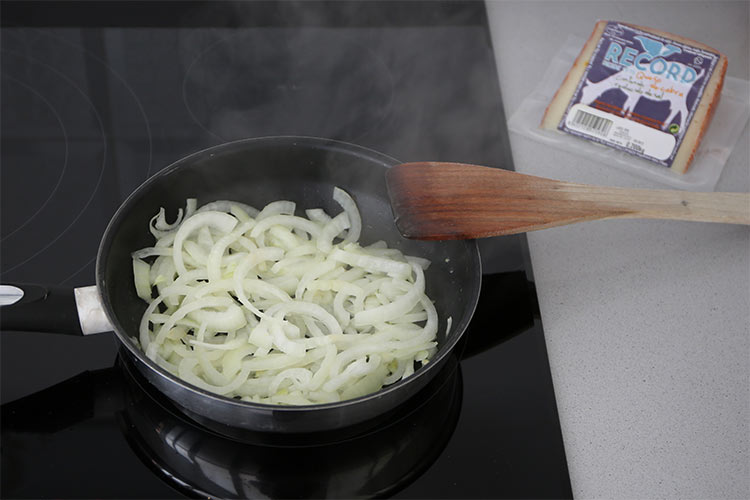Pochar la cebolla a fuego lento para hacer las empanadillas de sobrasada, queso y cebolla caramelizada