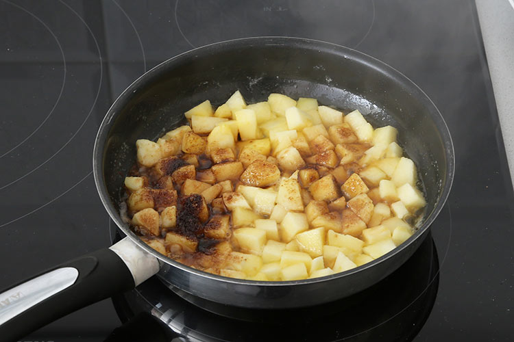 Cocinar la manzana con la mantequilla y el azúcar