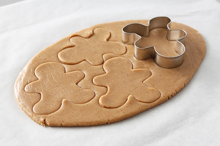 Cortar la masa de galletas con un cortador en forma de hombre de jengibre