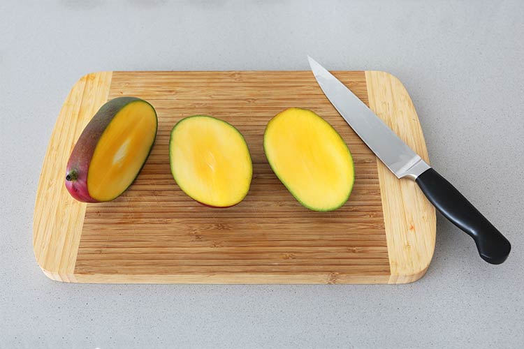 Разрежьте манго заподлицо с косточкой.