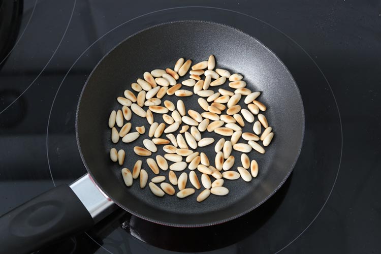 Tostar los piñones en una sartén