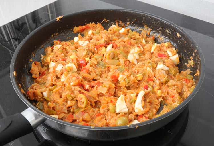 Añadir el atún, los huevos picados y las aceitunas al relleno de la empanada