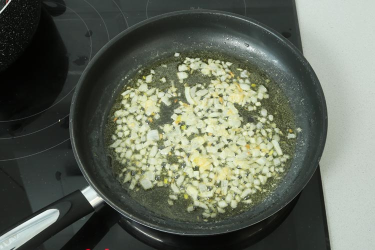 Saltear cebolla en mantequilla para hacer croquetas de marisco