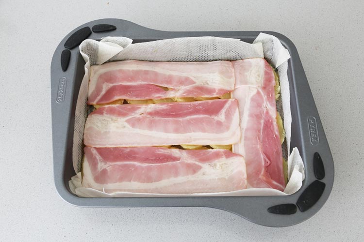 Dispón las lonchas de bacon y queso de forma alternativa sobre la patata