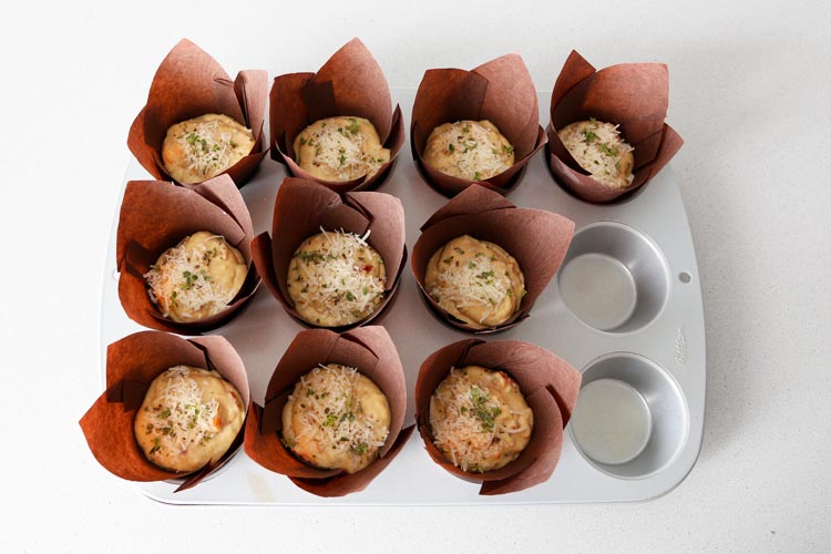 Espolvorear los muffins con queso rallado y una hierba aromática