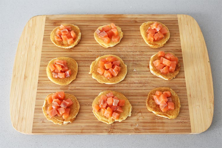 Colocar los trozos de salmón sobre los blinis