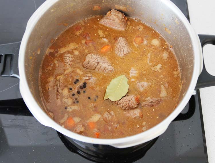 Incorporar la carne, la pimienta y el laurel al guiso