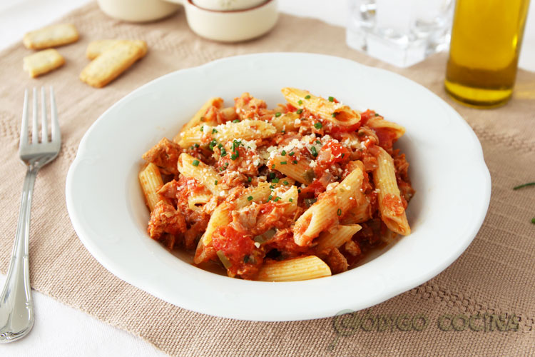 Pasta con tomate y atún espolvoreada con queso parmesano