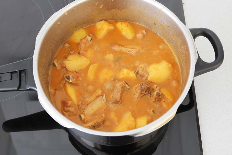 Incorporar las costillas al guiso y cubrir con agua