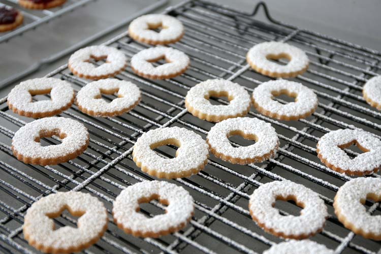 Espolvorear con azúcar glas sobre las galletas Linzer