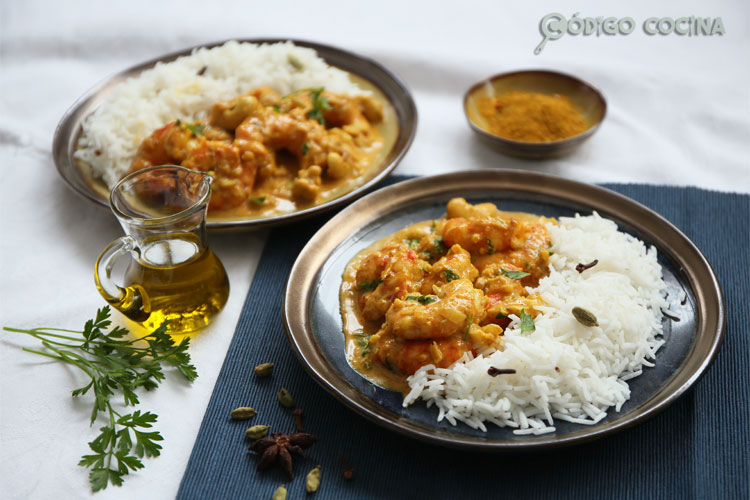 Dos platos con langostinos con salsa de curry y leche de coco acompañados de arroz basmati