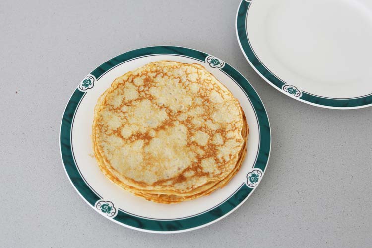 Varios crepes recién hechos con aspecto ligeramente dorado sobre un plato