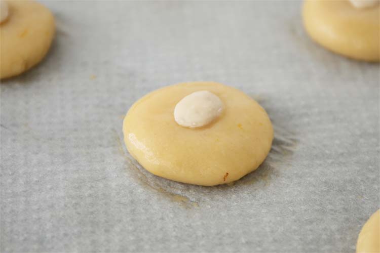 Dar forma a las pastas, pintar con huevo y decorar con una almendra