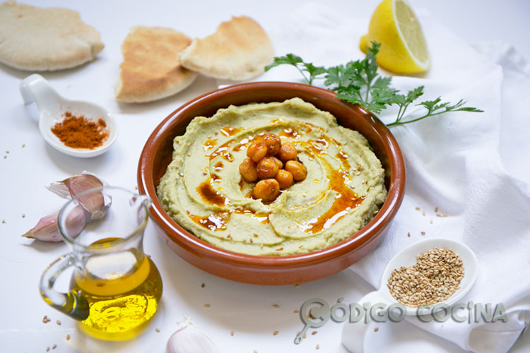 Hummus de aguacate decorado con aceite de oliva, pimentón y garbanzos