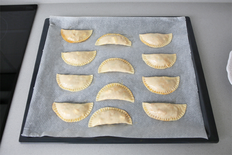 Colocar las empanadillas sobre la bandeja del horno y pintar con huevo