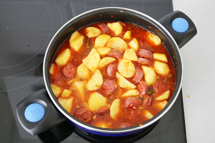 Añadir agua a las patatas con chorizo