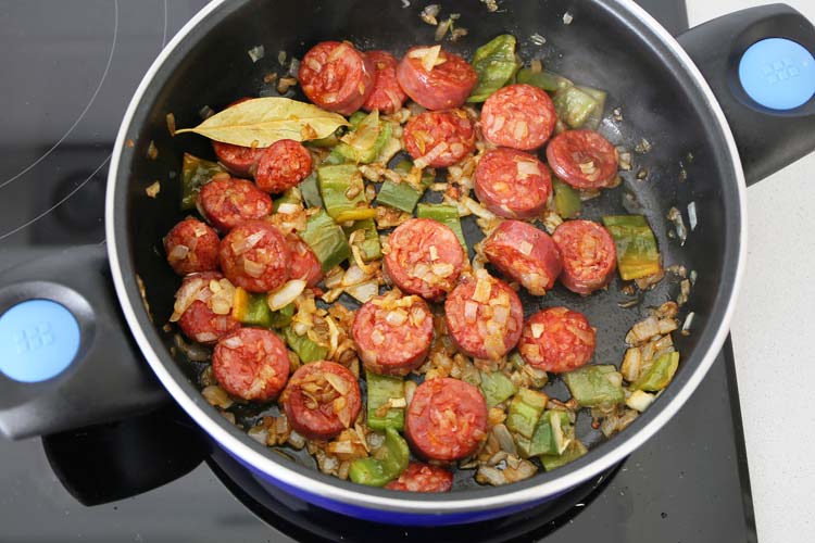 Sofrito de cebolla y pimiento verde con rodajas de chorizo fresco