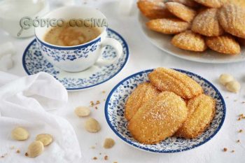 Madeleines de almendra fáciles colocadas sobre un plato con una tazá de café