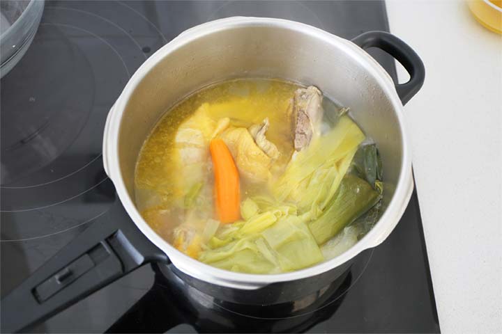 Olla con un caldo de pollo y verduras