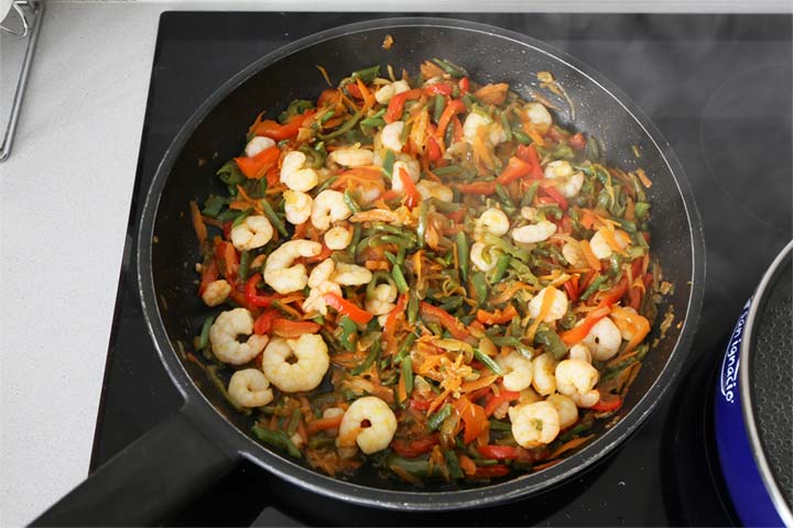 Añadir las gambas a las verduras