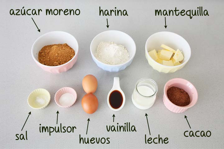 Ingredientes para hacer madeleines de chocolate colocados sobre una encimera