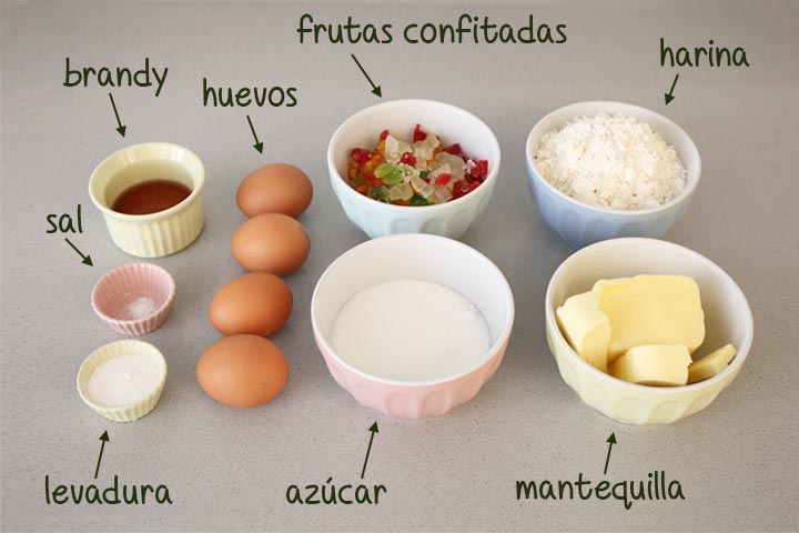 Ingredientes para hacer plum cake de fruta confitada preparados sobre una mesa