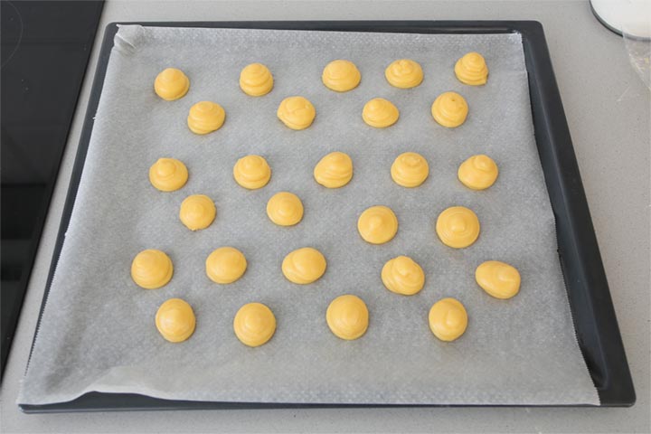 Masa de profiteroles escudillada sobre una bandeja de horno