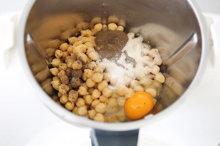 Garbanzos triturados con especias dentro de un robot de cocina