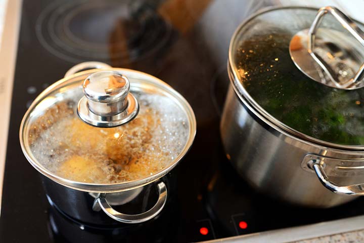 Cocinando en dos ollas de acero inoxidable con tapa de cristal