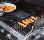 Hombre cocinando en una parrilla industrial