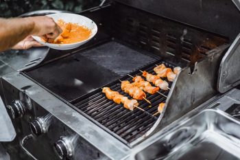 Hombre cocinando en una parrilla industrial