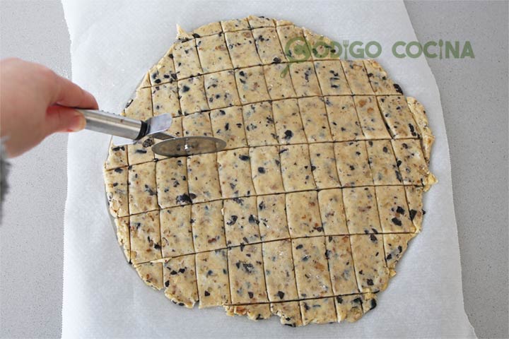 Cortar las galletas de parmesano con aceitunas y nueces